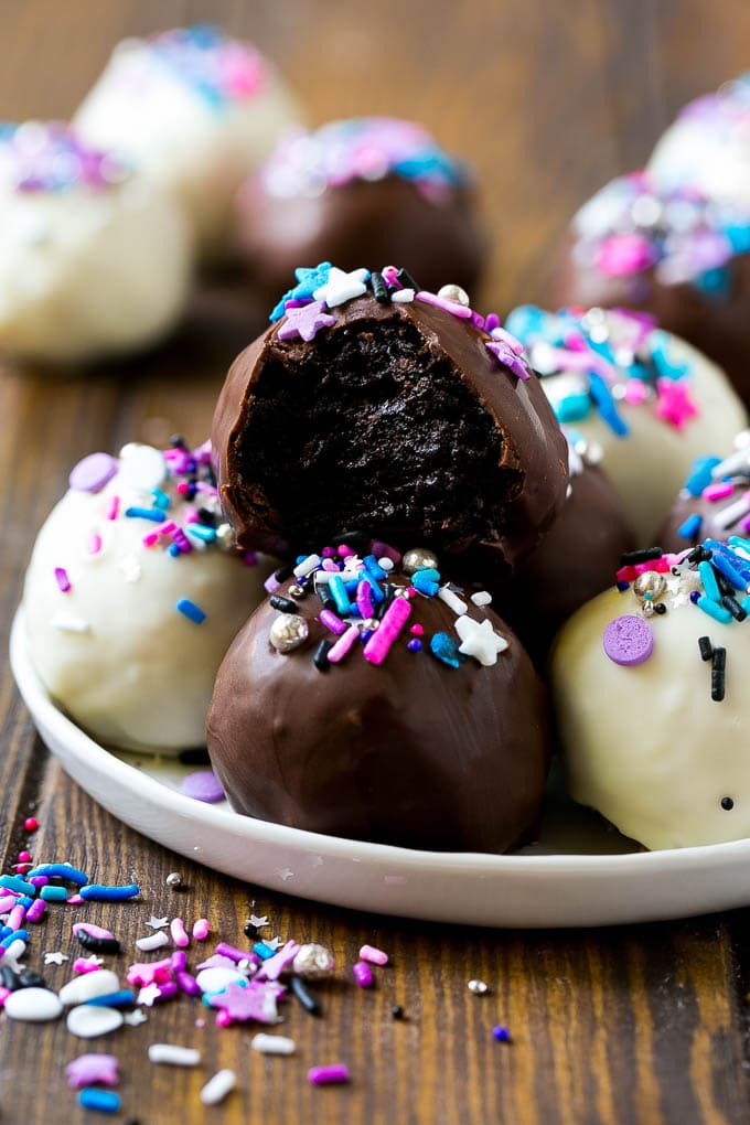 Oreo Balls Recipe | Oreo Truffles | Homemade Candy #truffles #candy #oreos #chocolate #sprinkles #dessert #christmas #ezlod A plate of dark and white chocolate Oreo balls topped with colorful sprinkles.