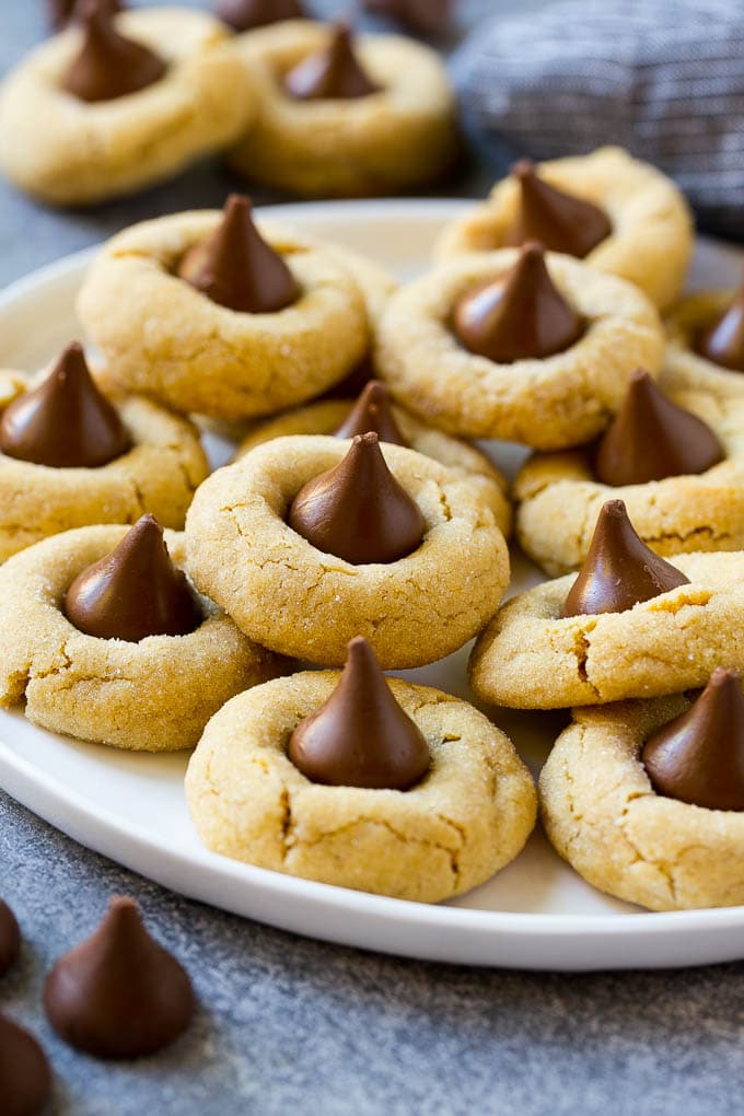 Peanut Butter Blossoms Recipe | Hershey Kiss Cookies | Chocolate Peanut Butter Cookies #cookies #peanutbutter #chocolate #dessert #baking #christmas #christmascookies #ezlod A serving plate of peanut butter blossoms.