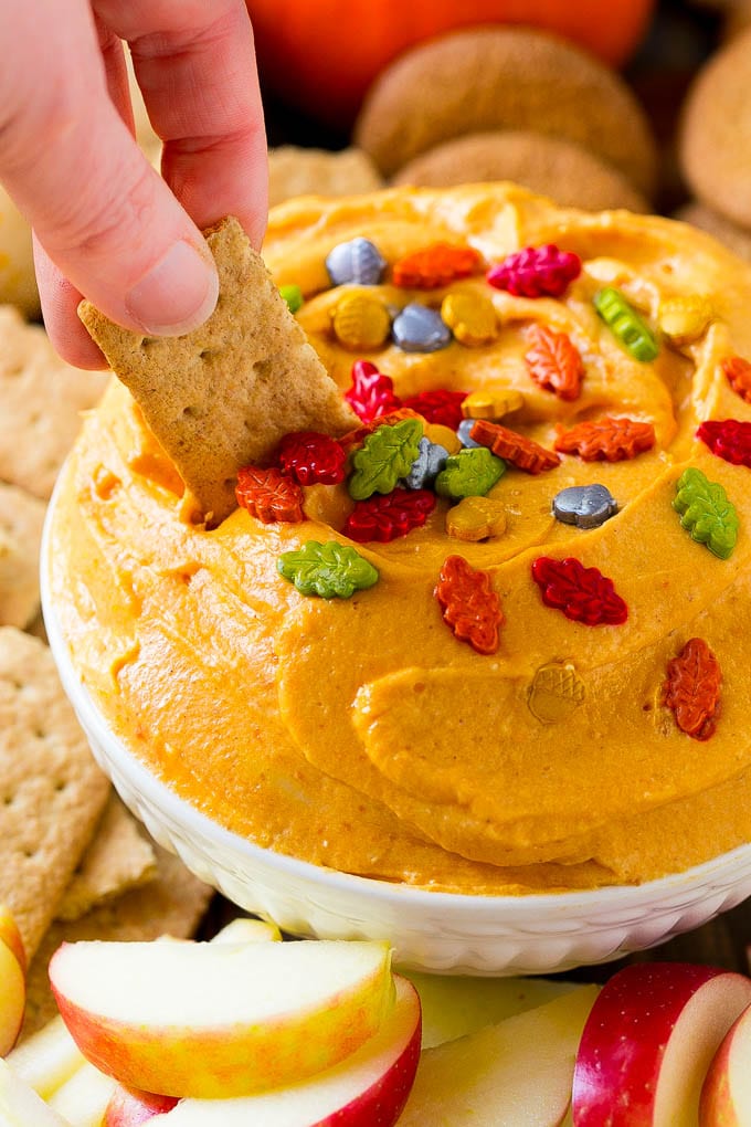 Pumpkin Dip Recipe | Dessert Dip | Pumpkin Pie Dip #pumpkin #dessert #dip #fall #thanksgiving #ezlod A bowl of pumpkin dip with a graham cracker scooping some out.