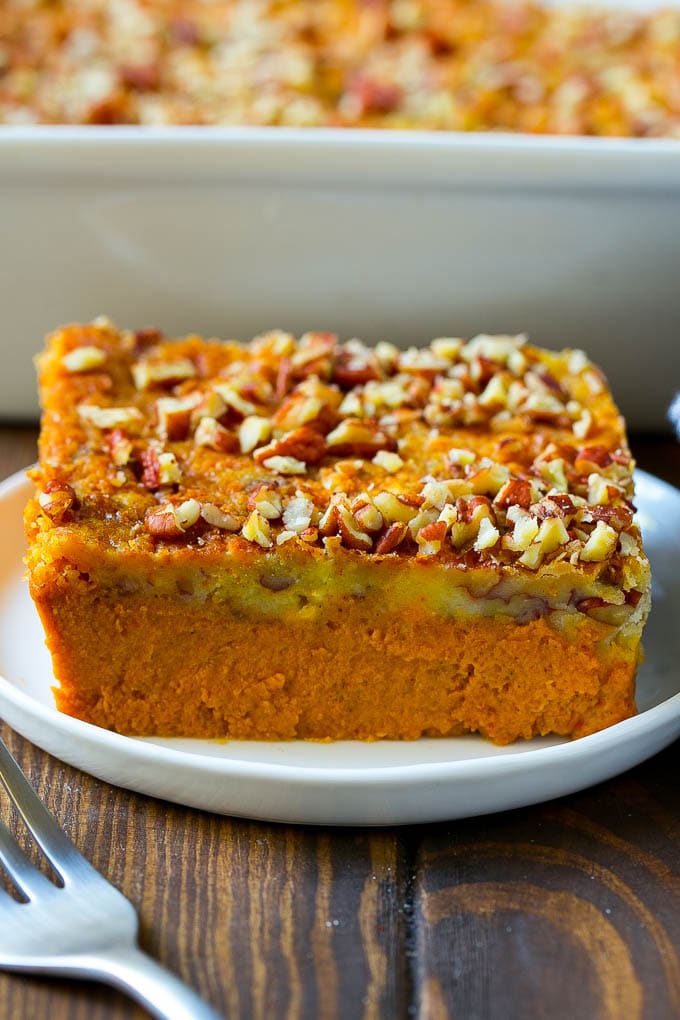 Pumpkin Dump Cake Recipe | Pumpkin Cake | Pumpkin Pie Cake #pumpkin #cake #pecans #fall #thanksgiving #dessert #ezlod A slice of pumpkin dump cake topped with pecans.
