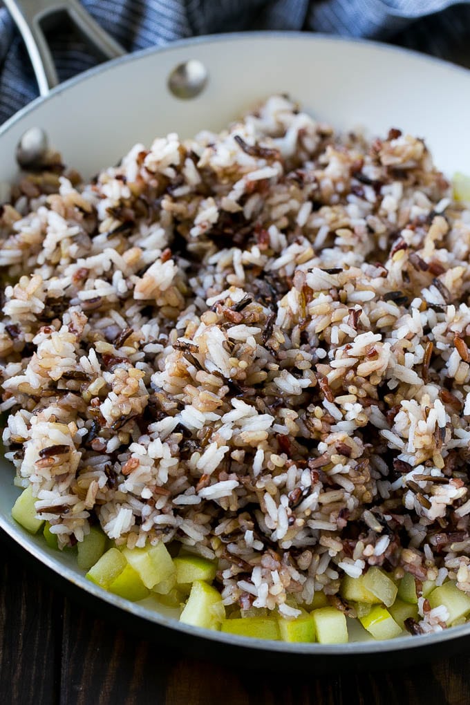 Wild Rice Pilaf Recipe | Thanksgiving Side Dish | Rice Pilaf #rice #apple #cranberry #fall #glutenfree #thanksgiving #ezlod WIld rice, onions and apples in a skillet.