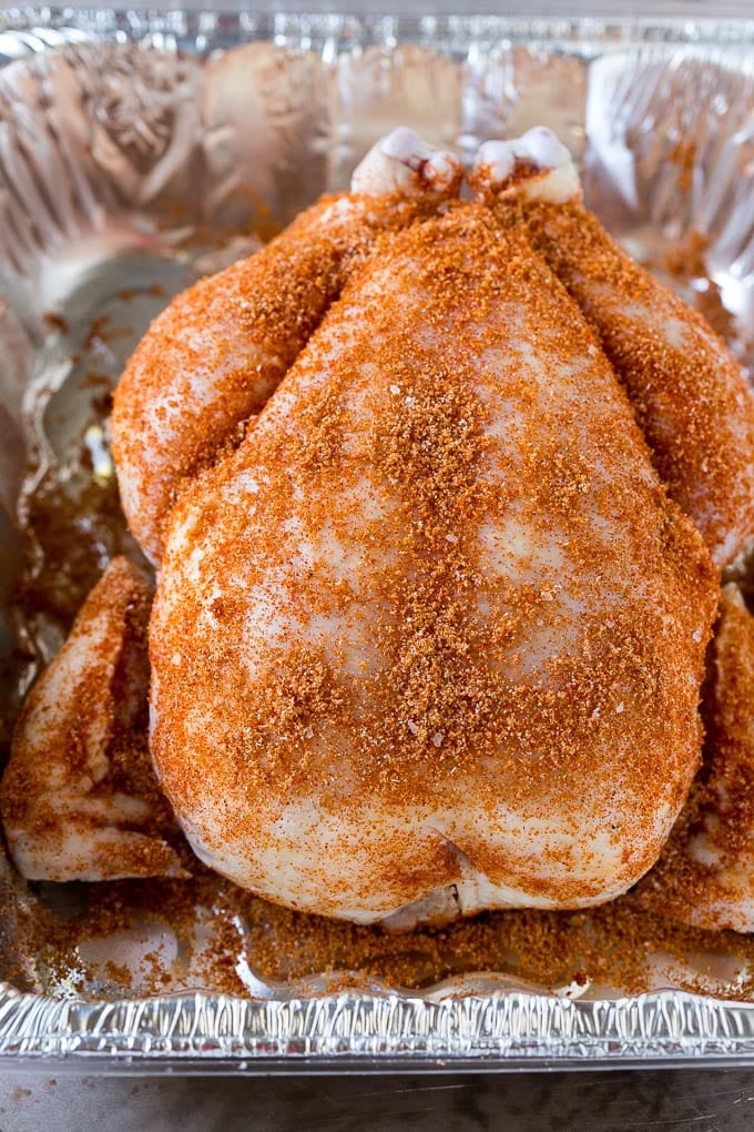 Smoked Chicken Recipe | Whole Smoked Chicken | BBQ Chicken #chicken #smoker #BBQ #dinner #ezlod #glutenfree #lowcarb A raw bird is coated with homemade spice rub in a roasting pan.