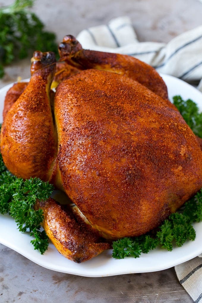 Smoked Chicken Recipe | Whole Smoked Chicken | BBQ Chicken #chicken #smoker #BBQ #dinner #ezlod #glutenfree #lowcarb Smoked chicken on a serving platter garnished with parsley.