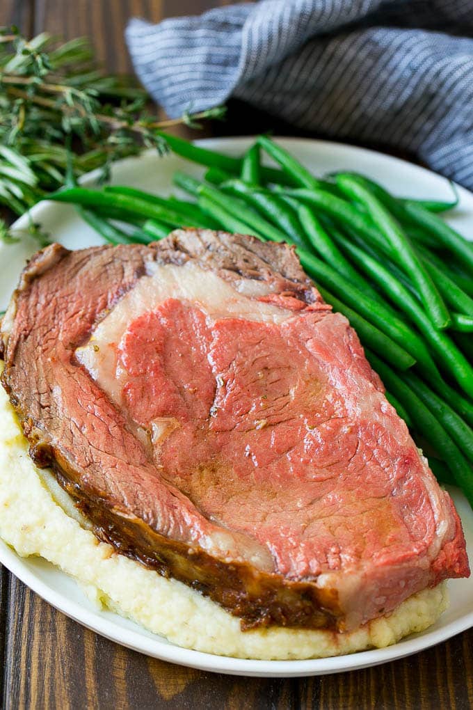 Smoked Prime Rib Recipe | Easy Prime Rib | Smoked Beef | Holiday Prime Rib #primerib #beef #smoker #dinner #ezlod #christmas #thanksgiving #lowcarb #keto A slice of prime rib over mashed potatoes with green beans on the side.