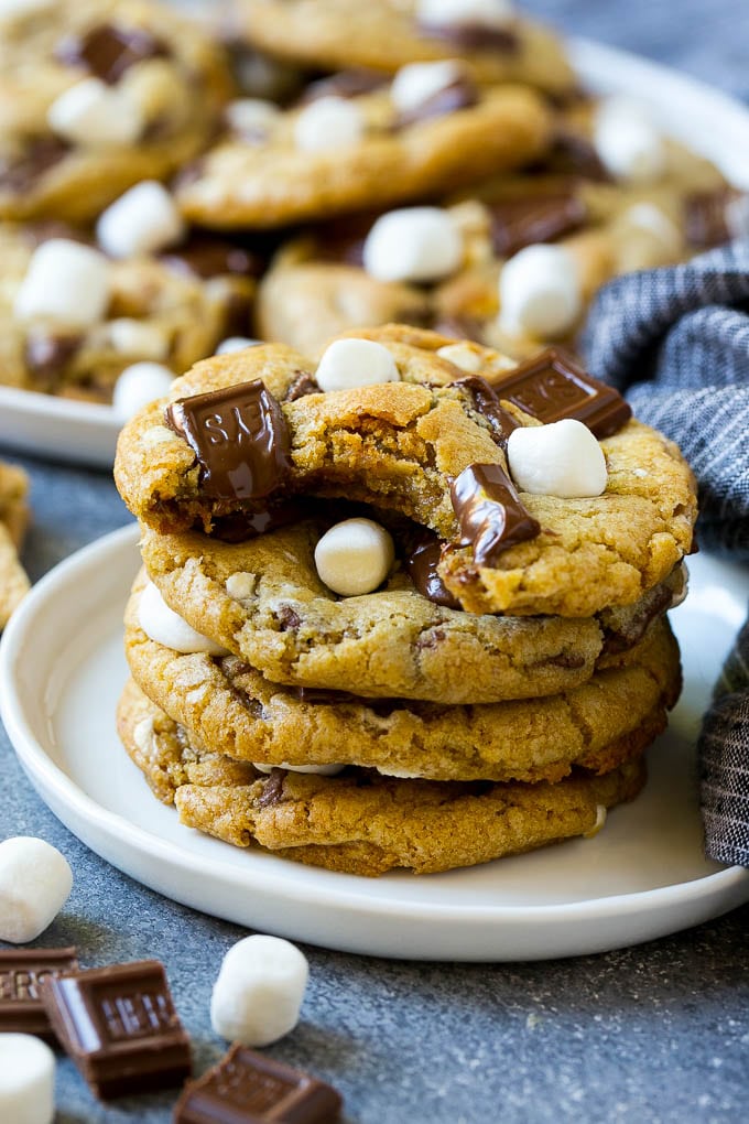 S'mores Cookies Recipe | Marshmallow Cookies #smores #marshmallow #chocolate #cookies #dessert #ezlod A stack of S'mores cookies with a bite taken out of one.