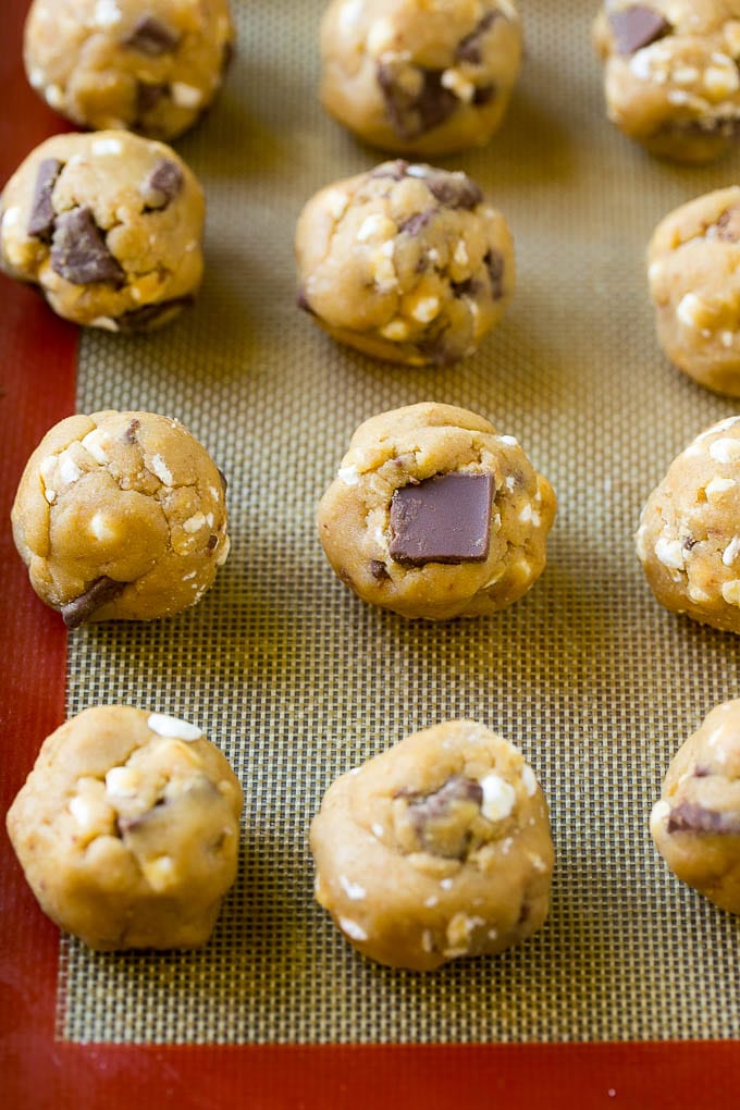 S'mores Cookies Recipe | Marshmallow Cookies #smores #marshmallow #chocolate #cookies #dessert #ezlod Balls of cookie dough on a baking sheet.