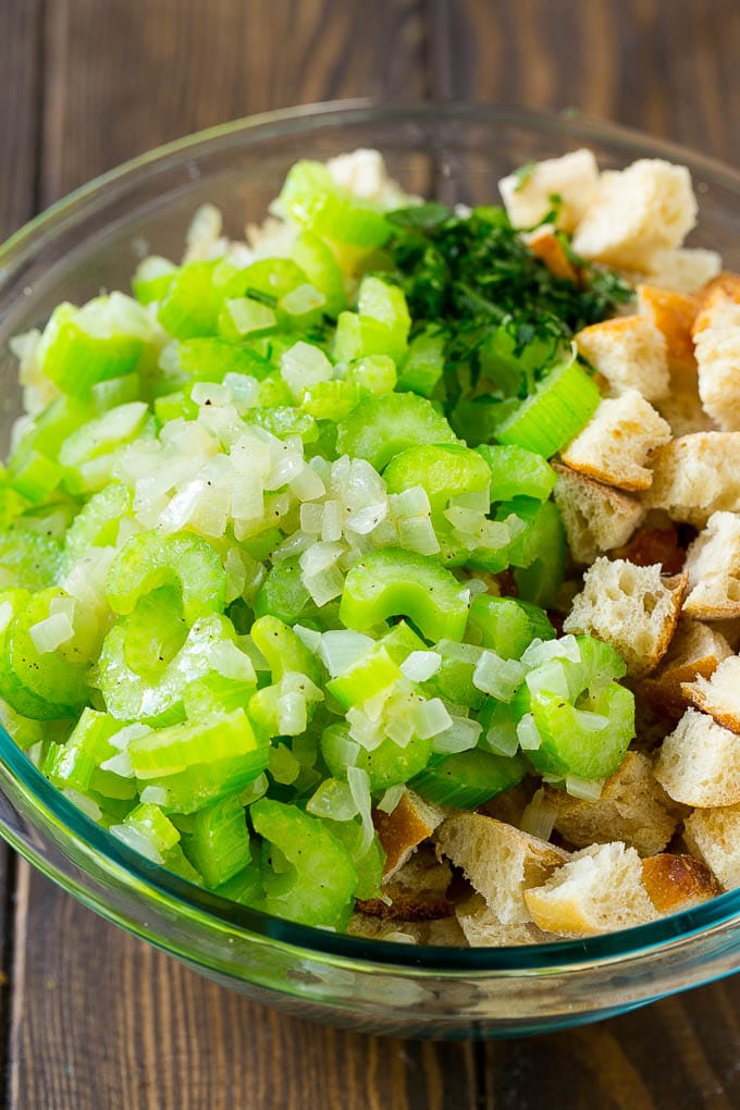 Turkey Stuffing Recipe | Thanksgiving Stuffing | Classic Stuffing #thanksgiving #stuffing #sidedish #fall #ezlod Bread cubes, celery, onion and herbs in a mixing bowl.