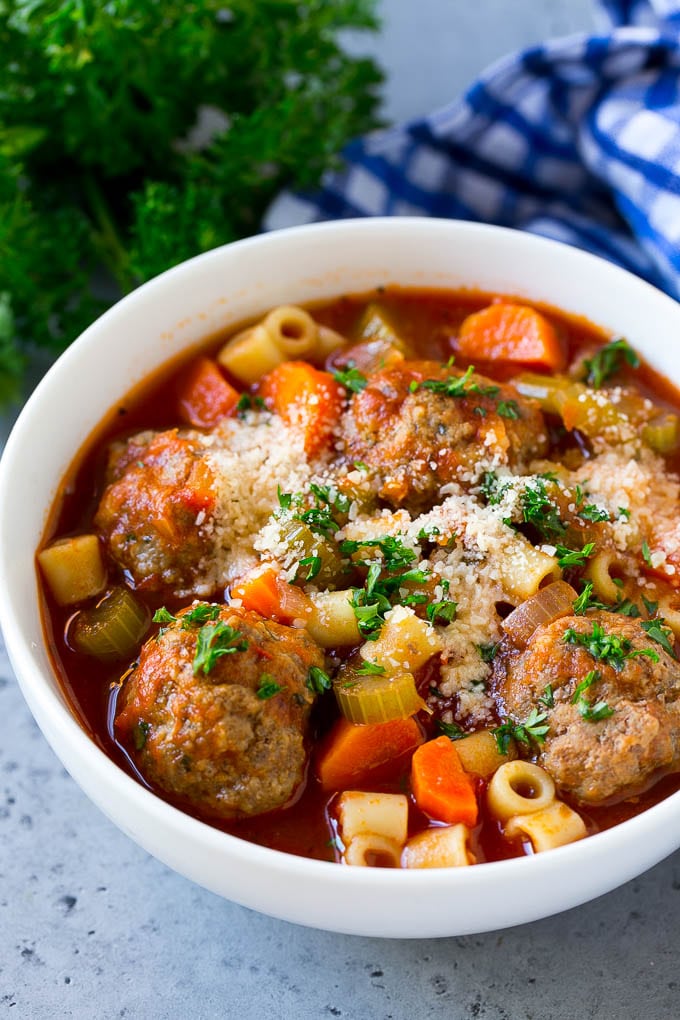 Italian Meatball Soup Recipe | Meatball Soup | Beef Meatballs #meatballs #beef #soup #italian #dinner #ezlod #comfortfood A bowl of meatball soup topped with chopped parsley and grated cheese.