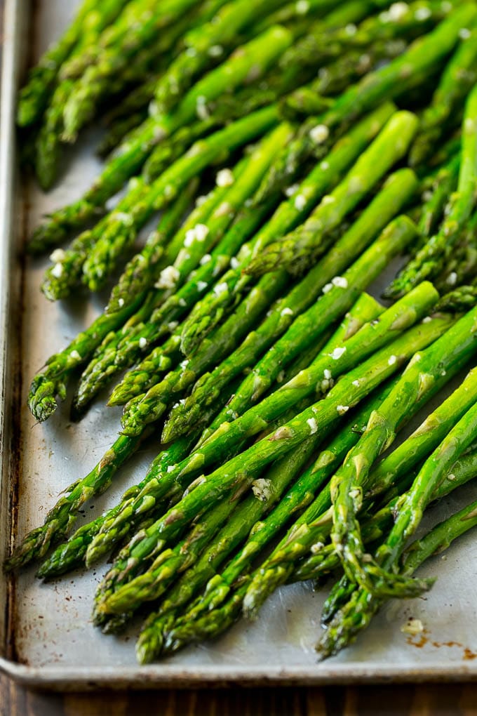 Roasted Asparagus Recipe | Baked Asparagus | Asparagus Side Dish #asparagus #garlic #sidedish #keto #lowcarb #dinner #ezlod Roasted stalks with garlic and olive oil on a baking sheet.
