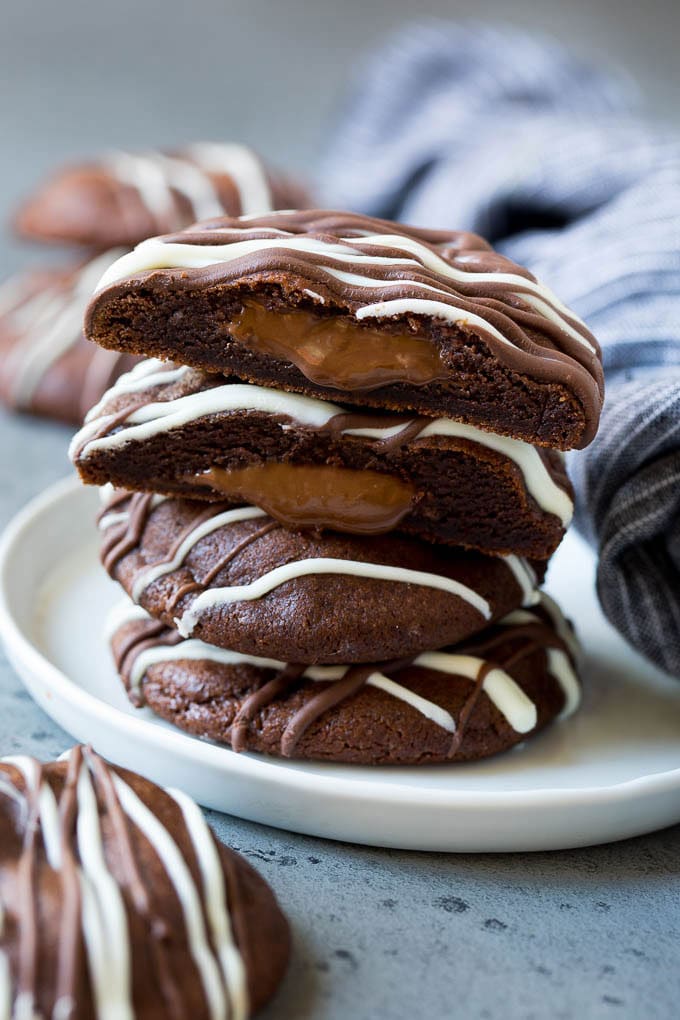 Nutella Cookies Recipe | Nutella Stuffed Cookies | Chocolate Cookies #nutella #chocolate #cookies #baking #dessert #ezlod A stack of Nutella cookies on a plate with one cut open.