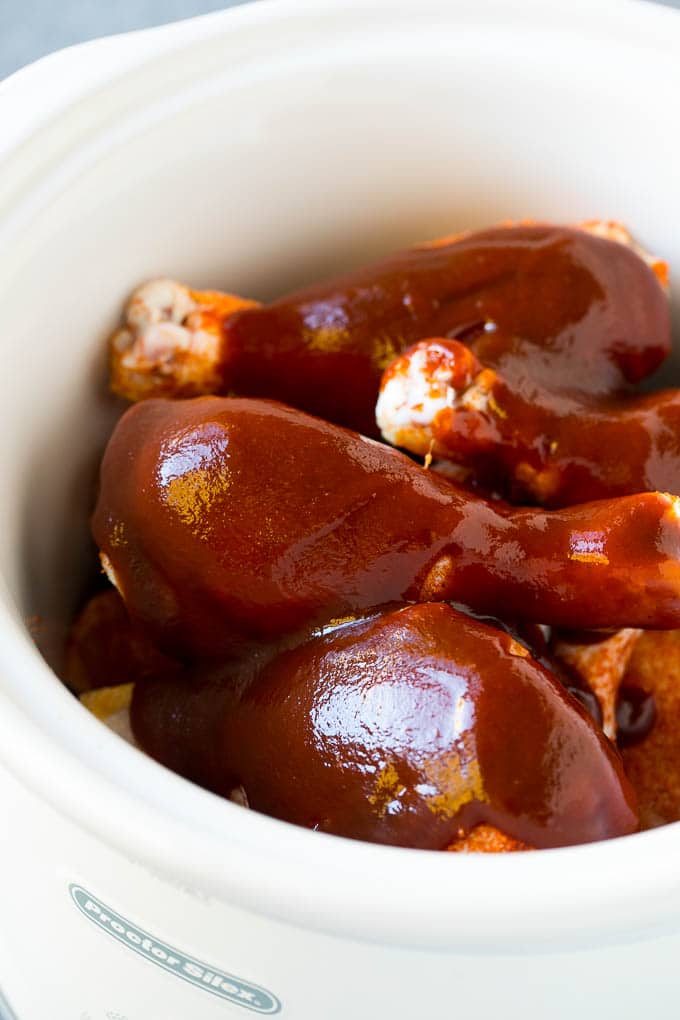Slow Cooker Chicken Drumsticks Recipe | Crock Pot Chicken Drumsticks | BBQ Chicken Drumsticks #chicken #drumsticks #slowcooker #crockpot #bbq #dinner #ezlod A crock pot of chicken drumsticks coated in BBQ sauce.