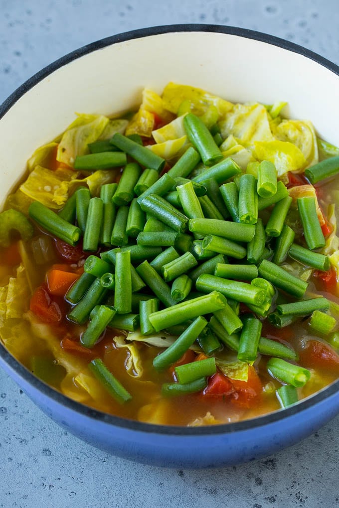 Cabbage Soup Recipe | Vegetable Soup | Veggie Soup | Healthy Soup #soup #healthy #cleaneating #cabbage #vegetables #veggies #dinner #ezlod Green beans in a pot of cooked veggies.