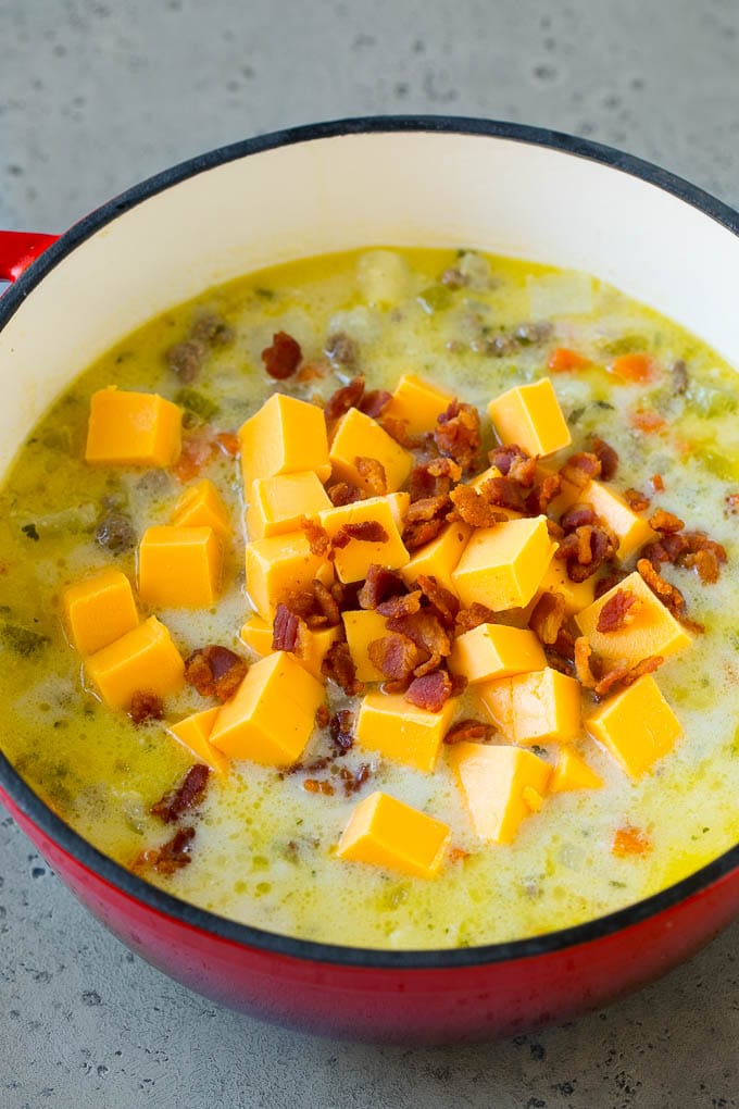 Cheeseburger Soup Recipe | Hamburger Soup | Cheese Soup #soup #groundbeef #hamburger #cheese #bacon #dinner #ezlod Potato soup base with cubes of Velveeta cheese and bacon being stirred in.