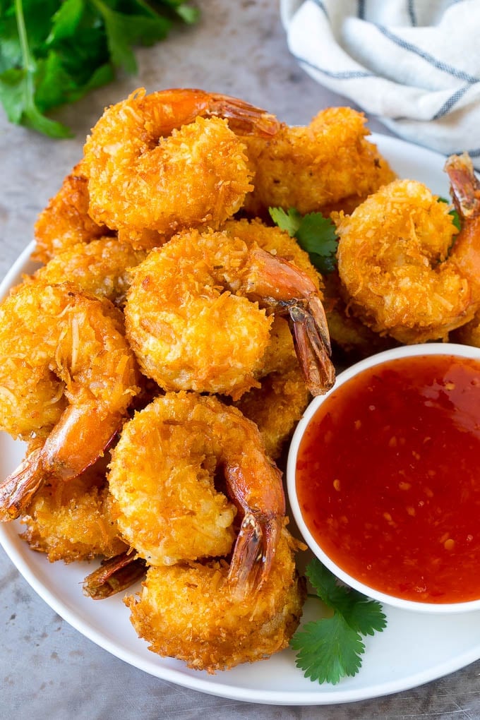 Coconut Shrimp Recipe | Fried Shrimp | Shrimp Appetizer #shrimp #coconut #appetizer #seafood #dinner #ezlod A plate of coconut shrimp with a bowl of sweet chili sauce.