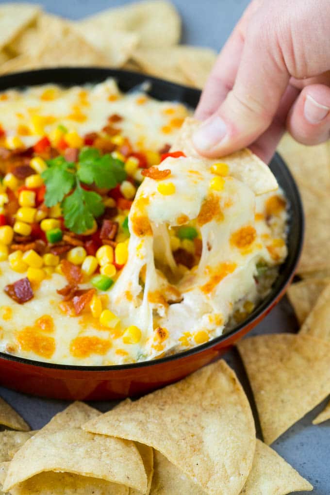 Corn Dip Recipe | Hot Cheese Dip | Bacon Dip #corn #dip #bacon #cheese #appetizer #snack #ezlod A chip scooping up a serving of corn dip.