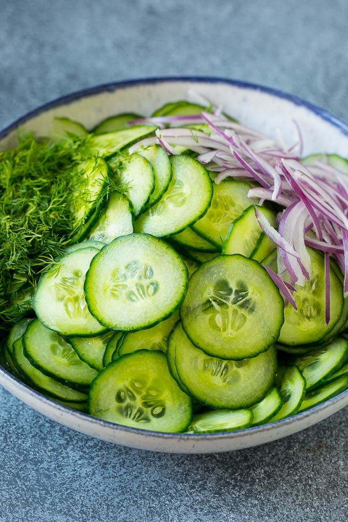 Cucumber Salad Recipe | Cucumber Dill Salad | Cucumber Recipe #cucumbers #salad #glutenfree #sidedish #ezlod Ingredients including red onion and dill in a bowl.