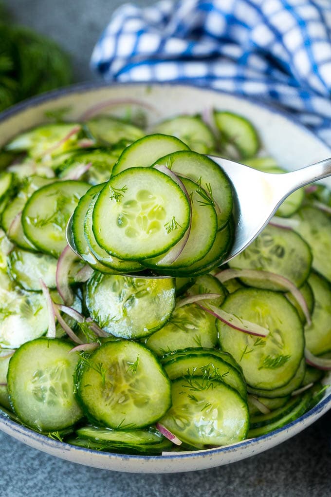 Cucumber Salad Recipe | Cucumber Dill Salad | Cucumber Recipe #cucumbers #salad #glutenfree #sidedish #ezlod A spoon serving up a portion of classic cucumber salad.
