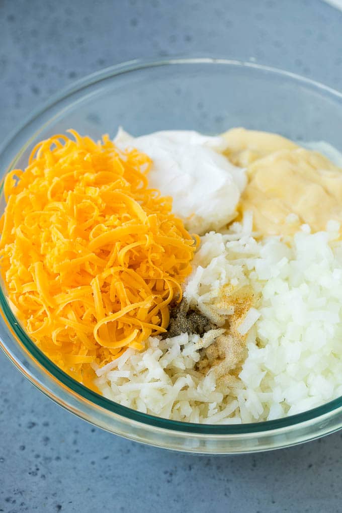 Hash Brown Casserole | Potato Casserole | Hash Brown Side Dish #potatoes #cheese #casserole #sidedish #ezlod A bowl of potato shreds, cheese, cream of chicken soup, sour cream and seasonings.