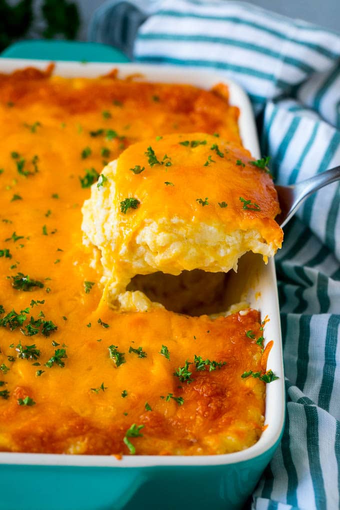 Hash Brown Casserole | Potato Casserole | Hash Brown Side Dish #potatoes #cheese #casserole #sidedish #ezlod A spatula pulling out a serving of cheesy hash brown casserole.