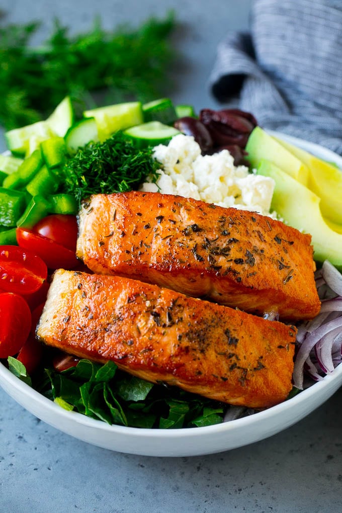 Greek Salmon Salad Recipe | Low Carb Salmon Recipe | Salmon Salad #salmon #seafood #fish #lowcarb #keto #lunch #ezlod #healthy Salmon fillets on lettuce with tomatoes, feta cheese, avocado, olives, cucumbers and herbs.