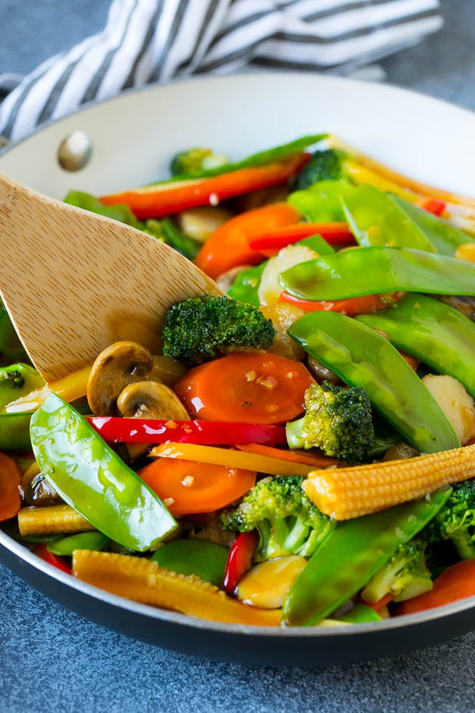Vegetable Stir Fry Recipe | Veggie Stir Fry | Broccoli Stir Fry #vegetarian #vegetables #broccoli #dinner #ezlod A spatula in a pan of veggie stir fry with carrots, snow peas and broccoli.