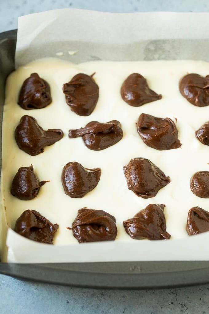 Cheesecake Brownies Recipe | Cream Cheese Brownies | Homemade Brownies #brownies #cheesecake #chocolate #dessert #ezlod Brownies topped with a layer of cheesecake and dollops of chocolate batter.