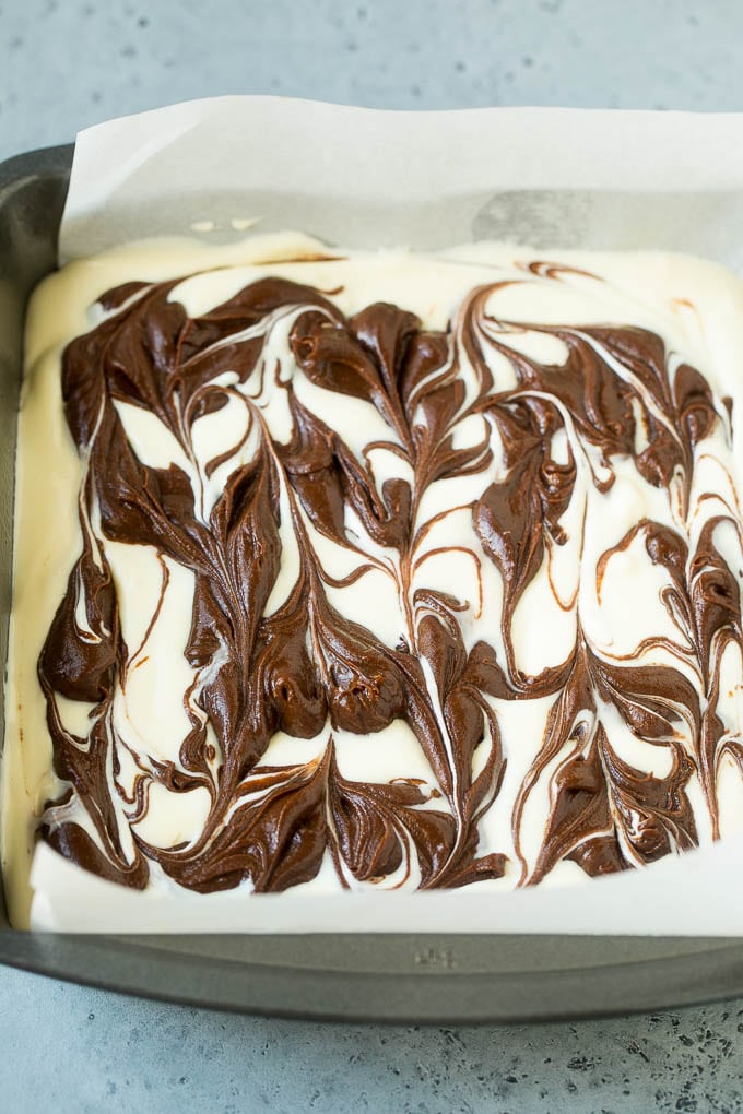Cheesecake Brownies Recipe | Cream Cheese Brownies | Homemade Brownies #brownies #cheesecake #chocolate #dessert #ezlod Swirled chocolate and cream cheese brownie batters in a baking pan.