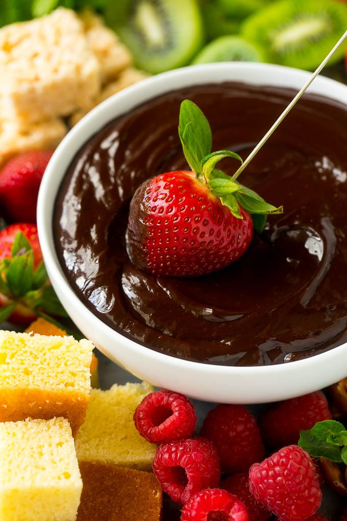 Chocolate Fondue Recipe | Chocolate Sauce | Chocolate Dip #chocolate #dessert #glutenfree #fondue #ezlod A strawberry being dipped into a bowl of fondue.