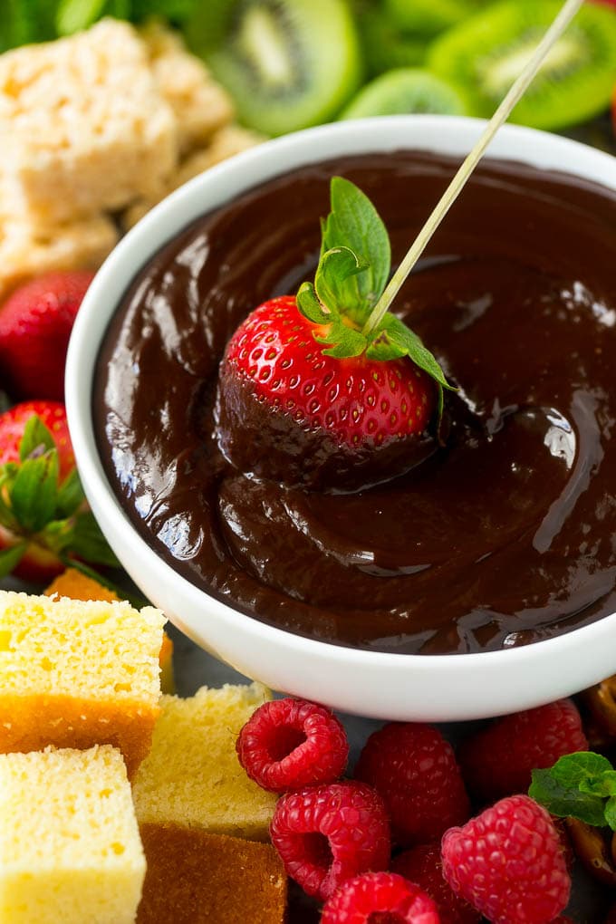 Chocolate Fondue Recipe | Chocolate Sauce | Chocolate Dip #chocolate #dessert #glutenfree #fondue #ezlod A strawberry on a skewer dipped into a bowl of chocolate fondue.