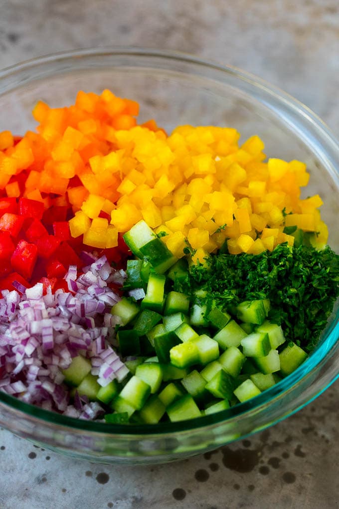 Israeli Salad Recipe | Cucumber Salad | Tomato Salad | Chopped Salad #salad #cleaneating #healthy #glutenfree #lowcarb #keto #sidedish #lunch #ezlod Chopped peppers, cucumbers, tomatoes and onions in a bowl.