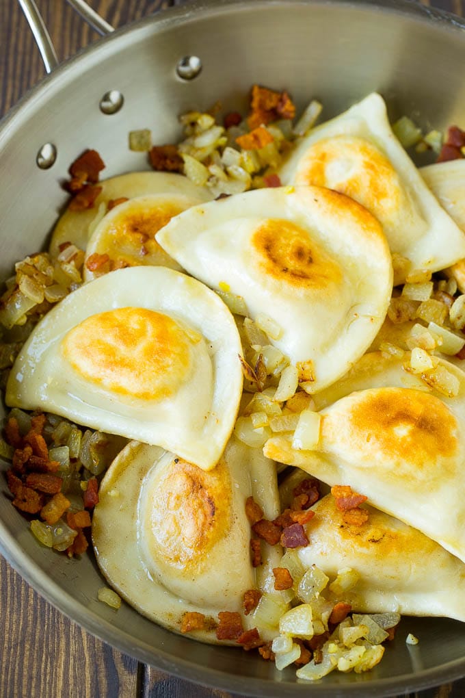 Pierogi Casserole Recipe | Potato Casserole #pierogis #casserole #bacon #cheddar #dinner #ezlod Sauteed pierogis with bacon and onions in a skillet.