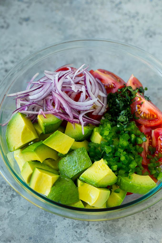 Tomato Avocado Salad Recipe | Avocado Salad | Tomato Salad #salad #tomato #avocado #glutenfree #cleaneating #dinner #ezlod #healthy Pieces of avocado, tomato, red onion and minced jalapeno in a salad bowl.