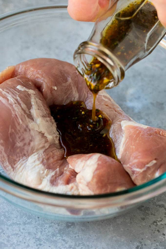 Marinated Pork Tenderloin Recipe | Pork Tenderloin Marinade | Pork Marinade #pork #porktenderloin #marinade #dinner #grilling #ezlod Marinade being poured over pork tenderloin.