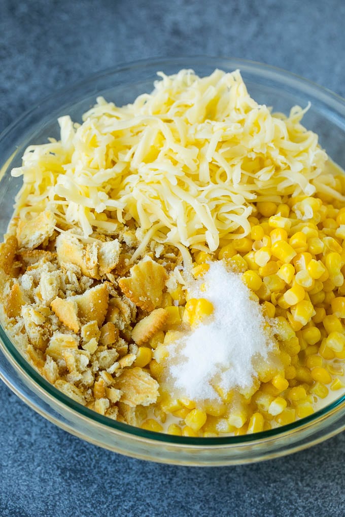 Scalloped Corn | Corn Casserole #corn #casserole #cheese #sidedish #dinner #ezlod Corn, crushed crackers, seasonings and shredded cheese in a bowl.
