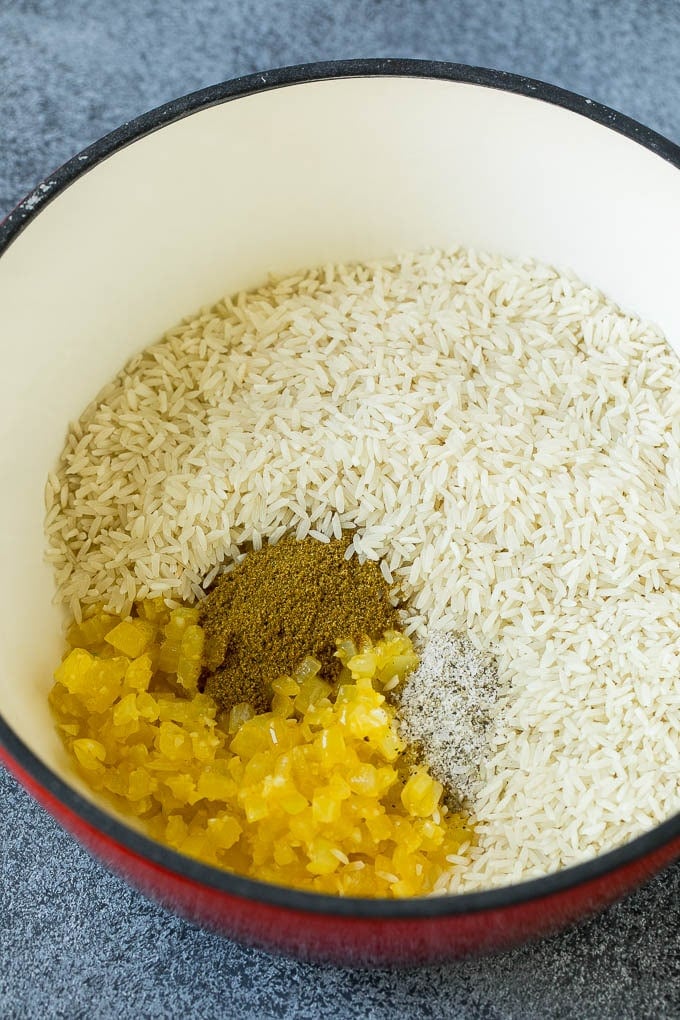 Black Beans and Rice Recipe | Cuban Black Beans | Beans and Rice #beans #rice #blackbeans #sidedish #glutenfree #dinner #ezlod Onions, garlic, white rice and spices in a pot.