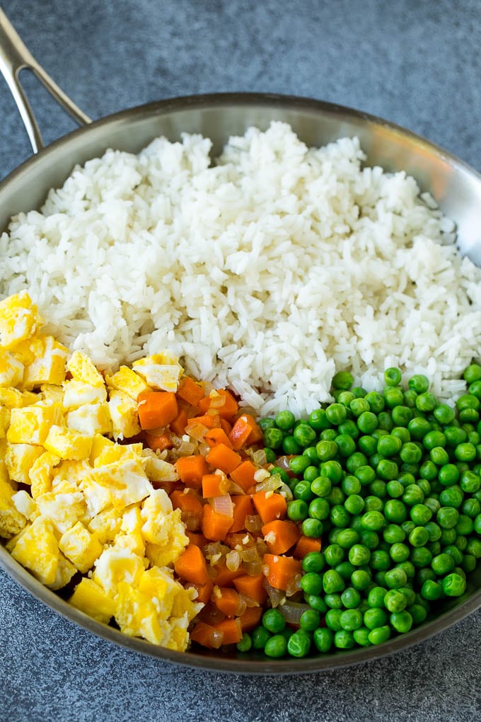Chicken Fried Rice Recipe | Chinese Fried Rice #rice #chicken #peas #carrots #sidedish #dinner #ezlod A pan of cooked rice, carrots, eggs and peas.