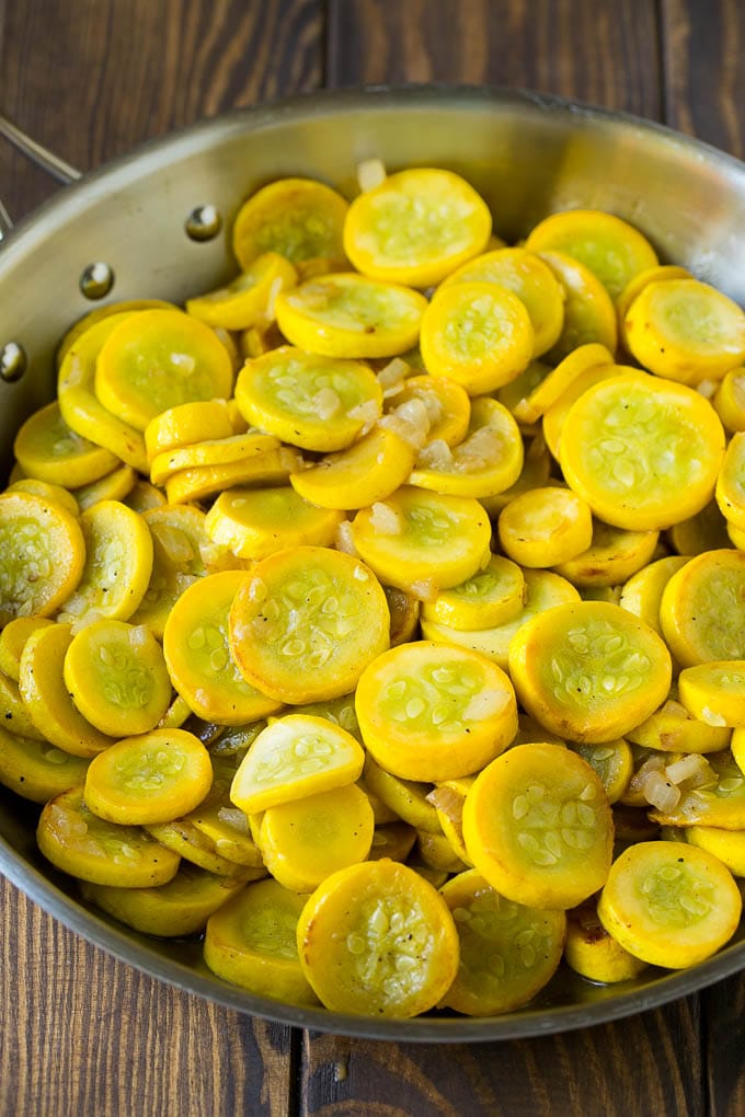 Squash Casserole Recipe | Vegetable Casserole | Zucchini Casserole #casserole #squash #zucchini #cheese #sidedish #ezlod Yellow squash and onions in a frying pan.