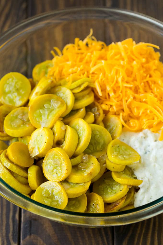 Squash Casserole Recipe | Vegetable Casserole | Zucchini Casserole #casserole #squash #zucchini #cheese #sidedish #ezlod Cooked yellow squash, creamy sauce and cheddar cheese in a mixing bowl.