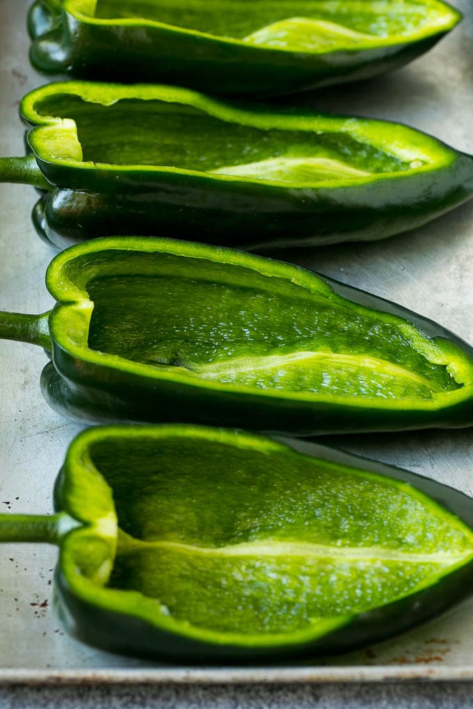 Stuffed Poblano Peppers | Stuffed Peppers | Pasilla Peppers #peppers #stuffedpeppers #beef #rice #beans #corn #dinner #ezlod Hollowed out poblano peppers on a pan.
