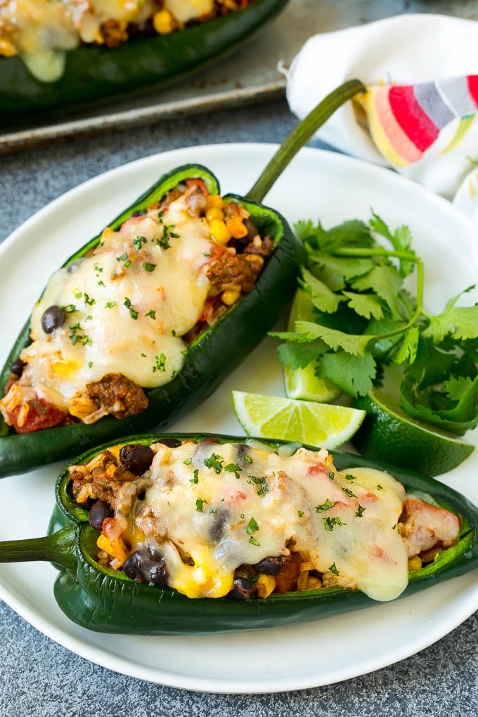 Stuffed Poblano Peppers | Stuffed Peppers | Pasilla Peppers #peppers #stuffedpeppers #beef #rice #beans #corn #dinner #ezlod A plate of stuffed poblano peppers topped with melted cheese.