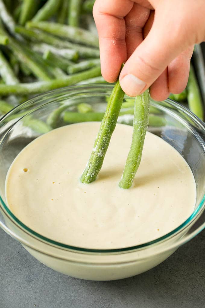 Fried Green Beans Recipe | Green Beans #greenbeans #appetizer #snack #ezlod A hand dipping beans into beer batter.