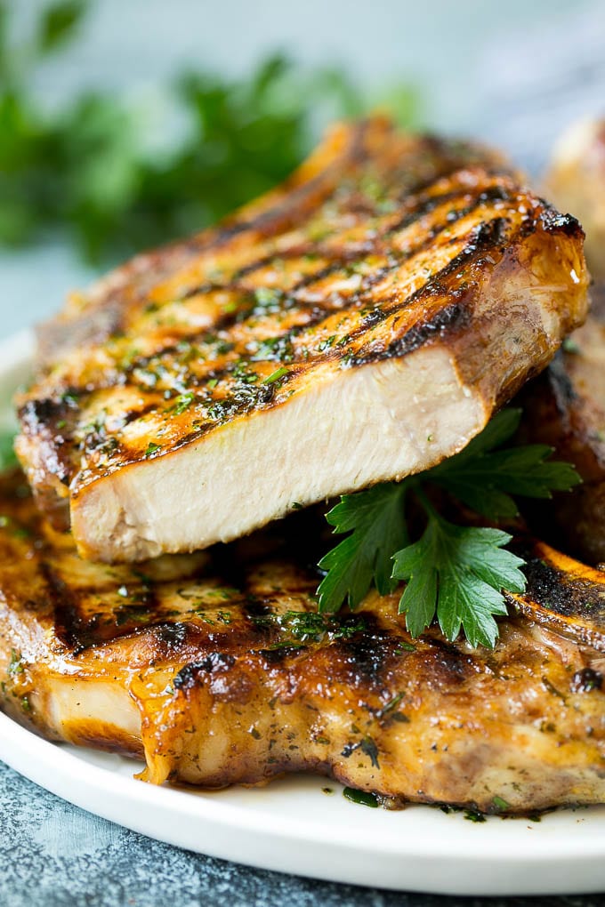 Grilled Pork Chops | Pork Chop Marinade #porkchops #grilling #pork #marinade #dinner #ezlod Grilled pork chops with a cut chop on top of the stack.