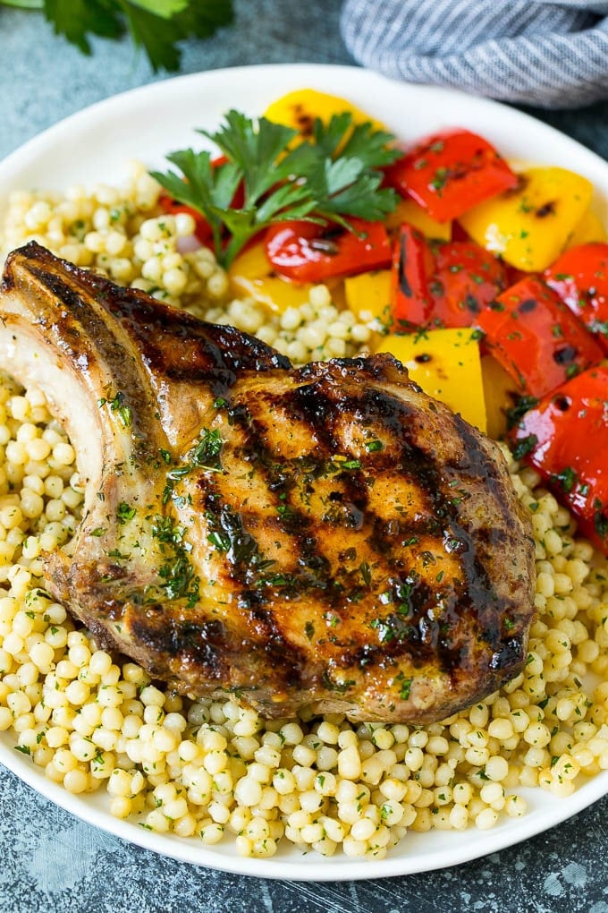 Grilled Pork Chops | Pork Chop Marinade #porkchops #grilling #pork #marinade #dinner #ezlod A grilled pork chop served over couscous with bell peppers on the side.