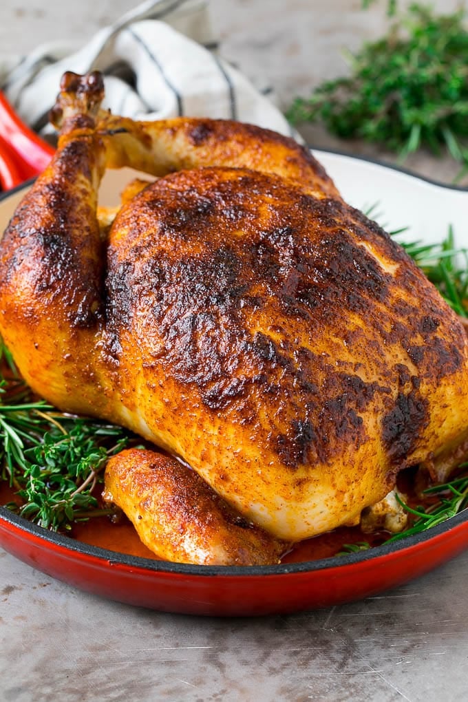 Rotisserie Chicken Recipe | Roasted Chicken #chicken #dinner #ezlod #comfortfood Rotisserie chicken in a skillet garnished with fresh herbs.