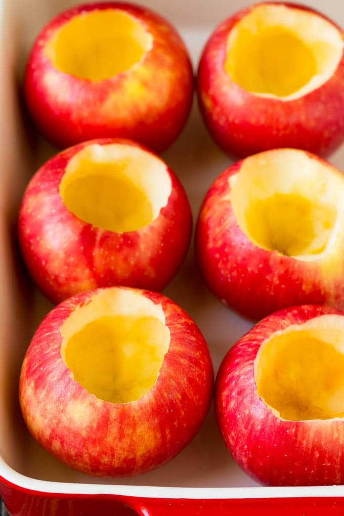 Baked Apples | Stuffed Apples #apples #fall #dessert #sweettooth #ezlod Hollowed out apples in a baking dish.