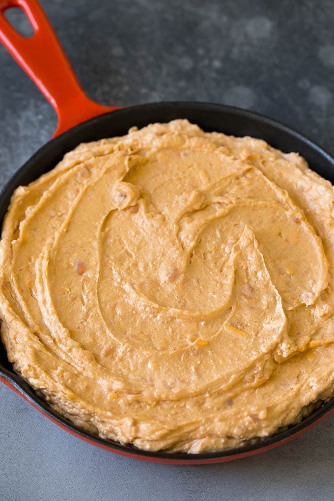 Bean Dip Recipe | Mexican Dip #dip #appetizer #mexicanfood #beans #cheese #ezlod Refried frijoles mixed with cream cheese, sour cream and seasonings in a skillet.