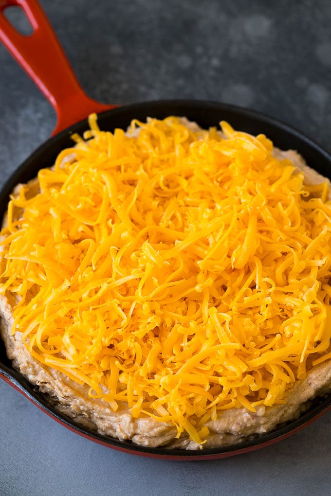 Bean Dip Recipe | Mexican Dip #dip #appetizer #mexicanfood #beans #cheese #ezlod The base topped with freshly shredded cheese.