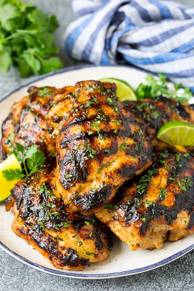 Grilled Chicken Thighs Recipe | Marinated Chicken Thighs #chicken #grilling #marinade #dinner #cilantro #lime #ezlod Grilled chicken thighs with a garnish of cilantro and lime wedges.
