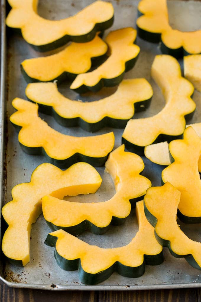 Roasted Acorn Squash | Acorn Squash Recipe #squash #winter #sidedish #dinner #ezlod Sliced acorn squash on a sheet pan.