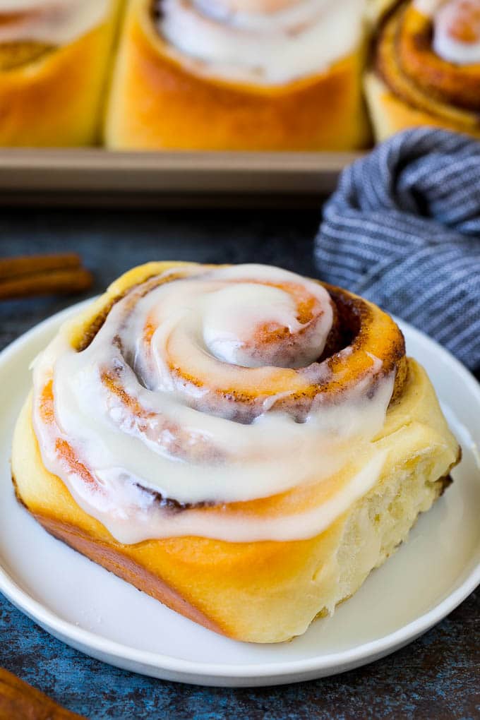 Cinnamon Rolls Recipe | Cinnamon Buns #cinnamon #rolls #pastry #breakfast #brunch #sweets #ezlod #baking #bread A frosted cinnamon bun on a serving plate.
